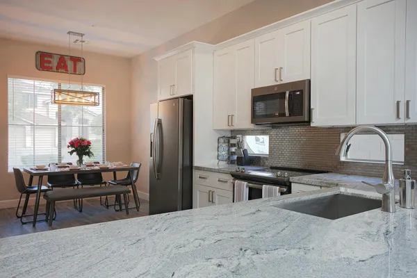 a kitchen with stainless steel appliances a stove refrigerator sink and microwave