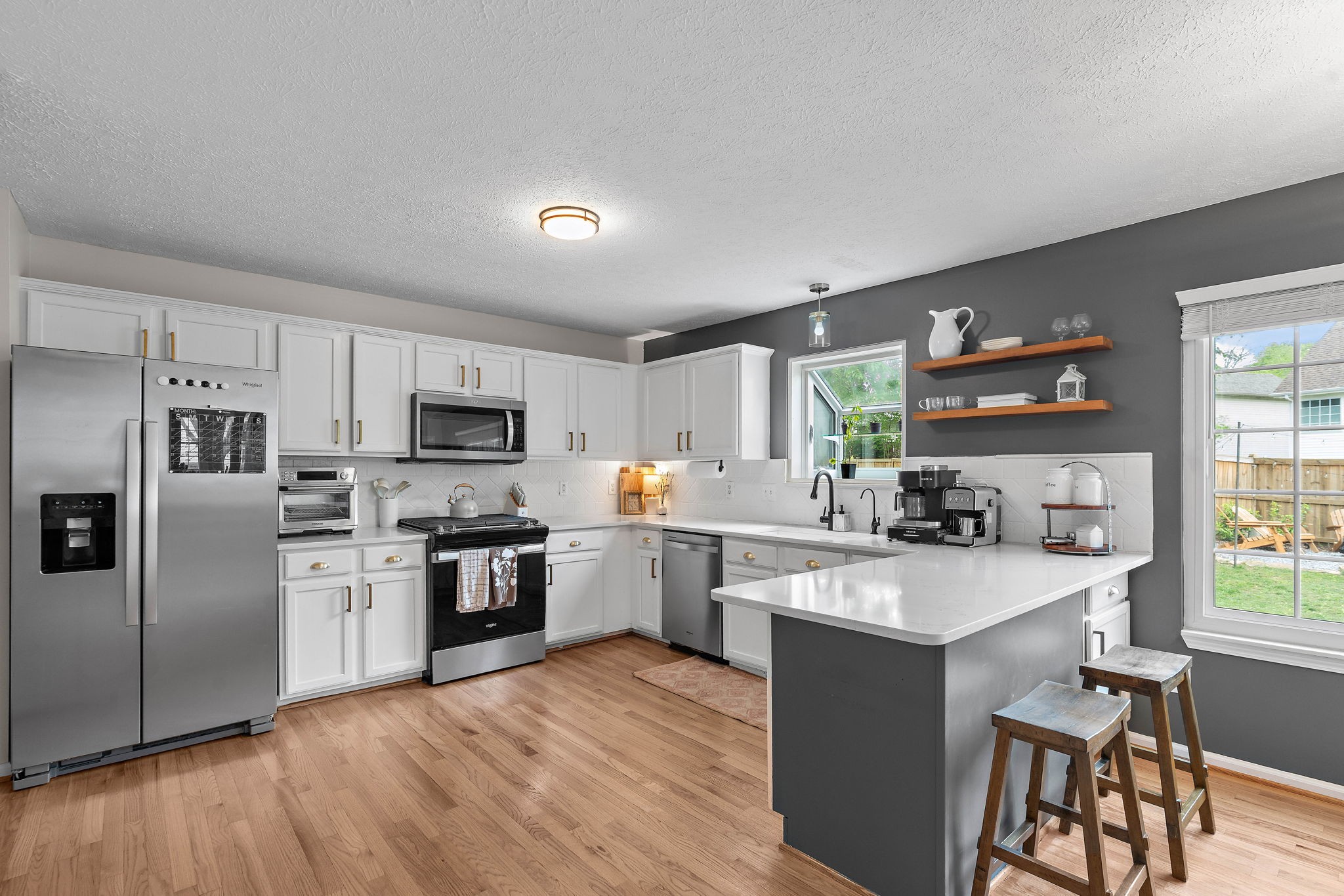 2104 Melody Drive Franklin, TN 37067 - Photo 11 of 30 a kitchen with stainless steel appliances granite countertop a stove top oven a sink dishwasher a refrigerator and a dining table with wooden floor