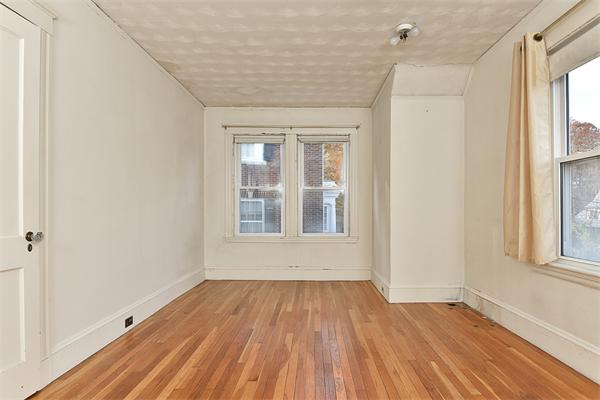 284 Pond Street Boston, MA 02130 - Photo 16 of 27 an empty room with wooden floor and windows