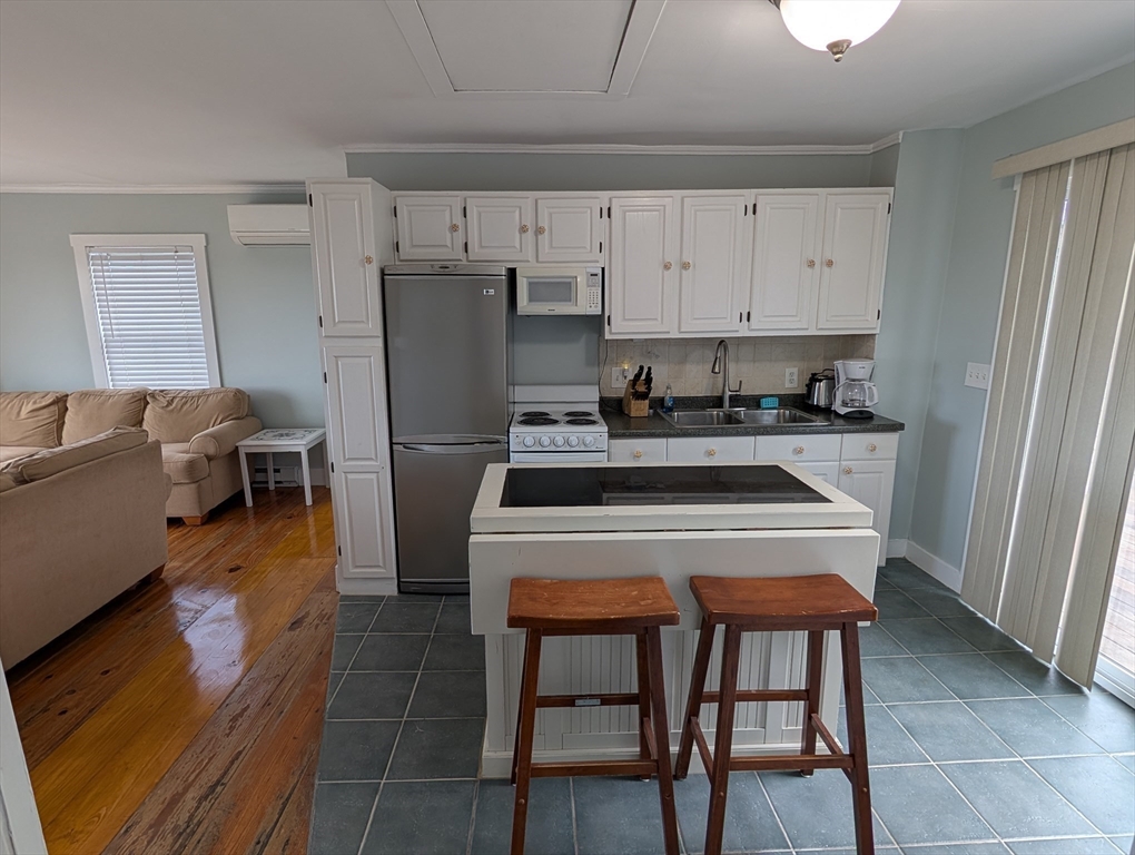 44 Old Point Road Newbury, MA 01951 - Photo 5 of 7 a kitchen with stainless steel appliances a stove a refrigerator and a fireplace