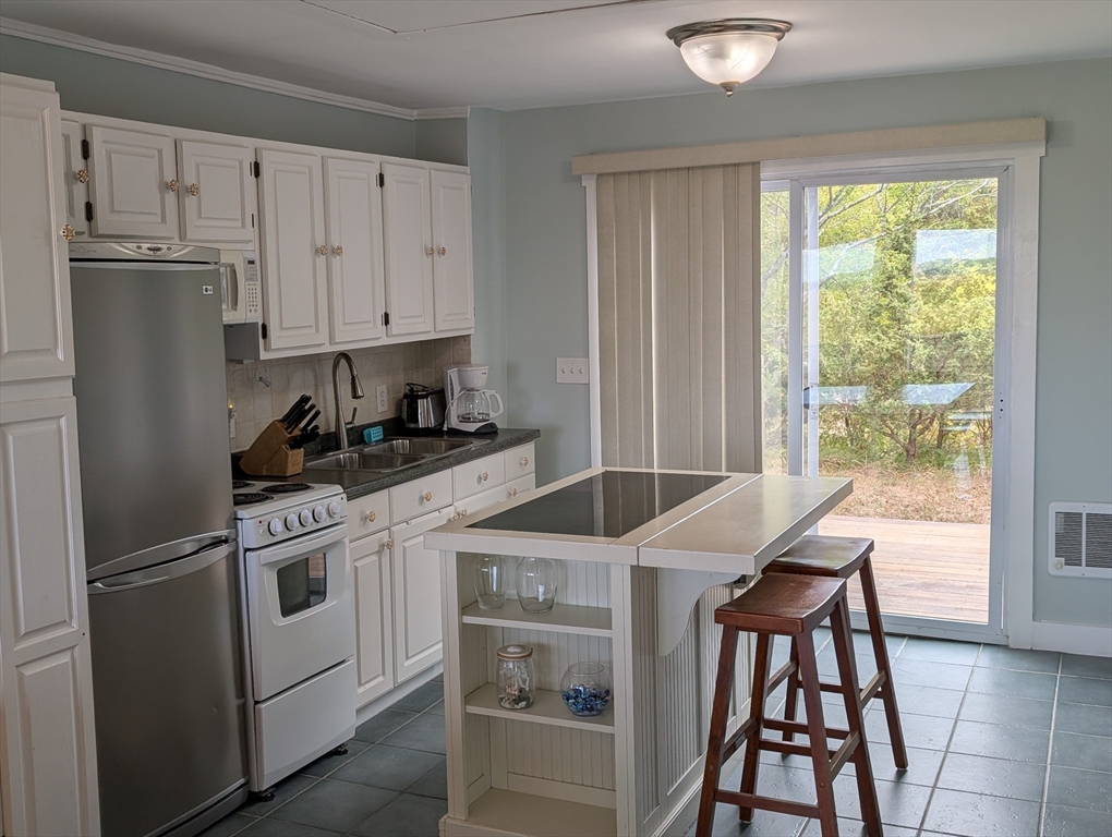 44 Old Point Road Newbury, MA 01951 - Photo 6 of 7 a kitchen with stainless steel appliances granite countertop a stove a refrigerator a sink and white cabinets with wooden floor
