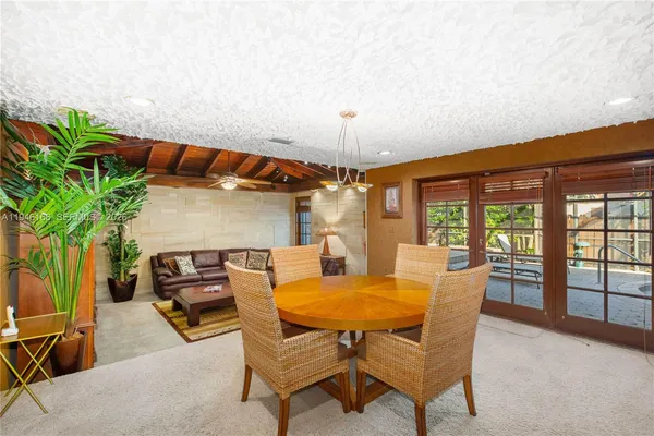 a dining room with furniture and a potted plant
