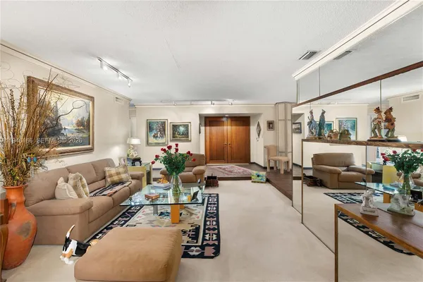 a living room with furniture large window and wooden floor