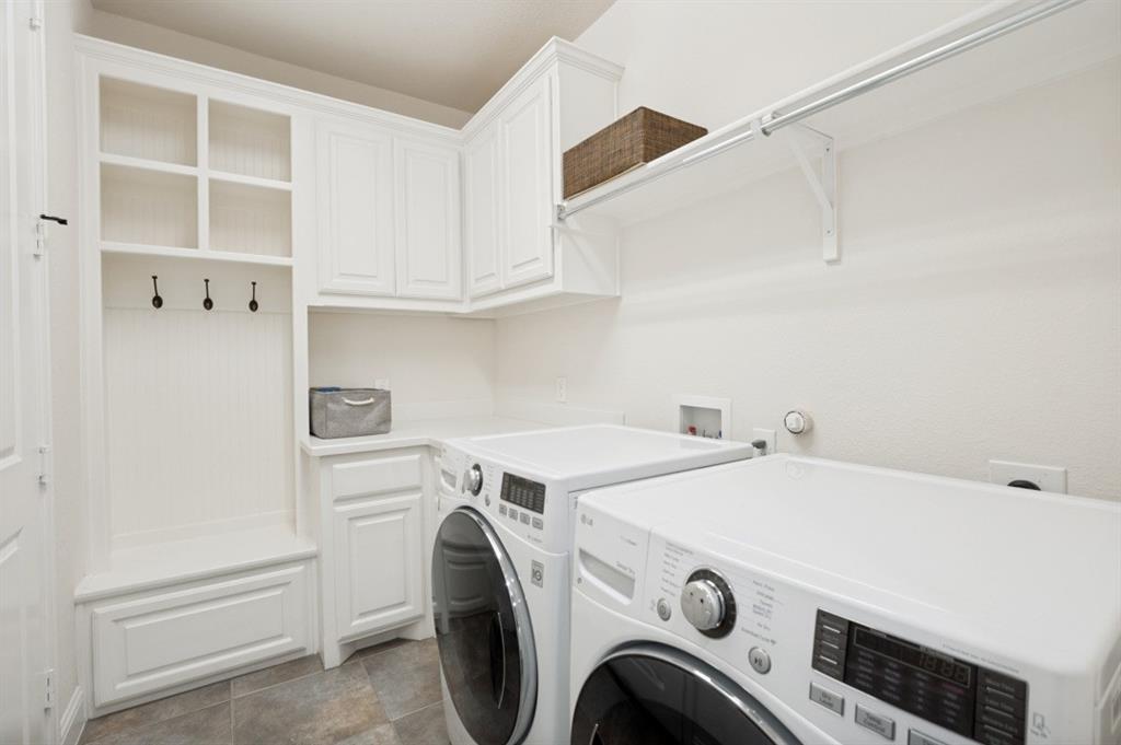 14215 Raspberry Lane Frisco, TX 75035 - Photo 12 of 30 Utility room featuring built-in white cabinetry, integrated mudroom bench with cubbies and hooks, ample counter space, and a wall-mounted shelving unit