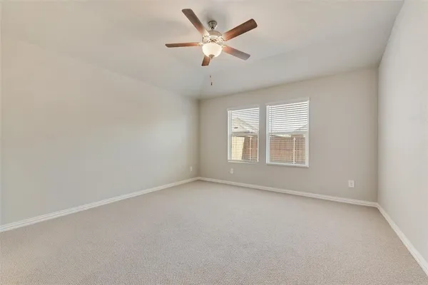 an empty room with a window and a ceiling fan