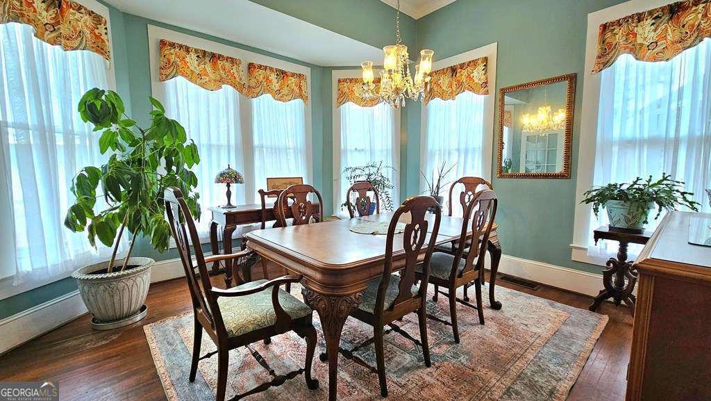810 South Lee Street, Unit 3 Fitzgerald, GA 31750 - Photo 8 of 22 a dining room with furniture potted plants and wooden floor