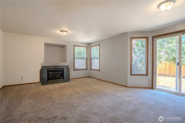 an empty room with a fireplace and a floor to ceiling window