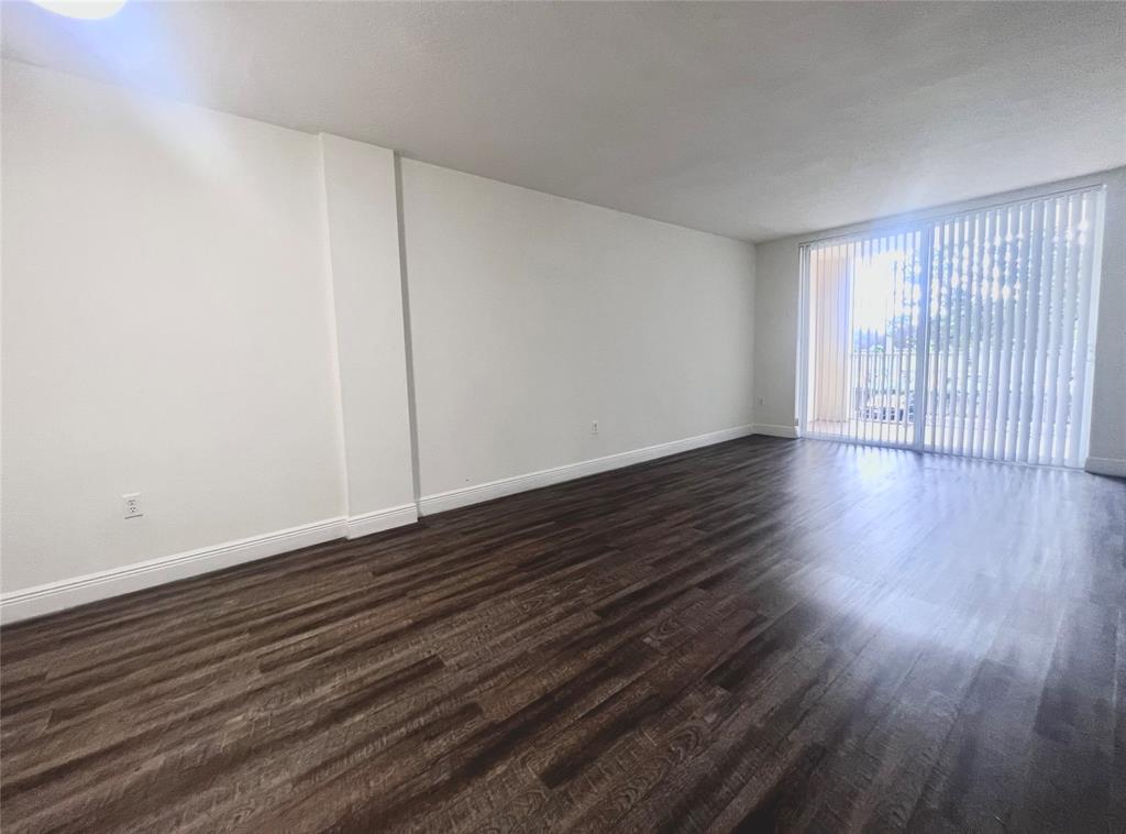 18335 Northwest 68th Avenue, Unit 255308 Hialeah, FL 33015 - Photo 2 of 17 a view of an empty room with wooden floor and a window