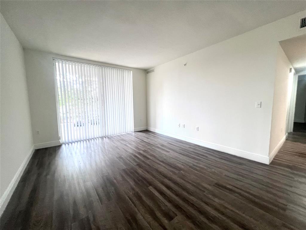 18335 Northwest 68th Avenue, Unit 255308 Hialeah, FL 33015 - Photo 4 of 17 a view of an empty room with wooden floor and a window
