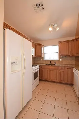 a kitchen with a refrigerator sink and cabinets