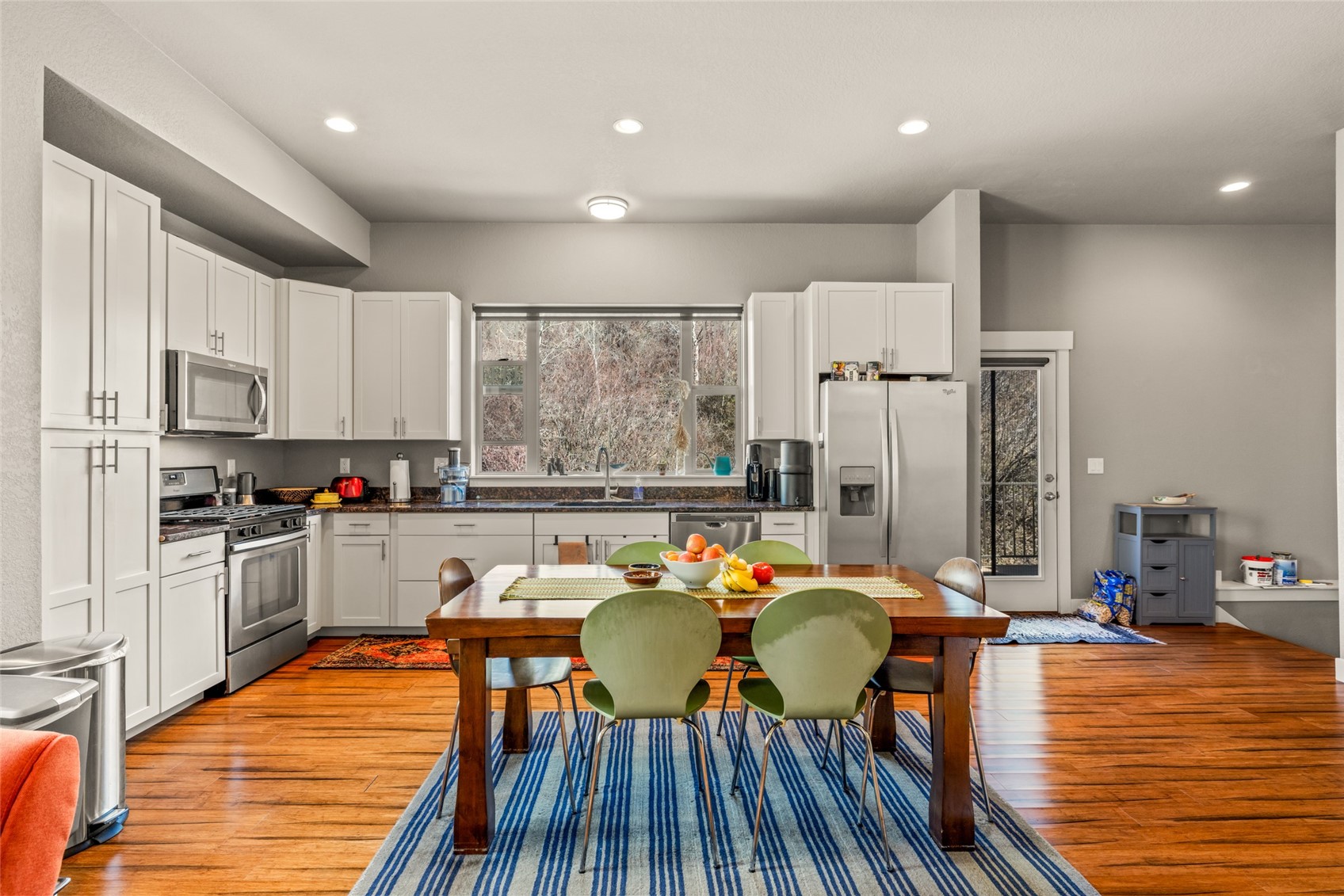 1680 Copper Ridge Drive, Unit 101 Steamboat Springs, CO 80487 - Photo 6 of 21 a kitchen with stainless steel appliances wooden floor dining table and chairs