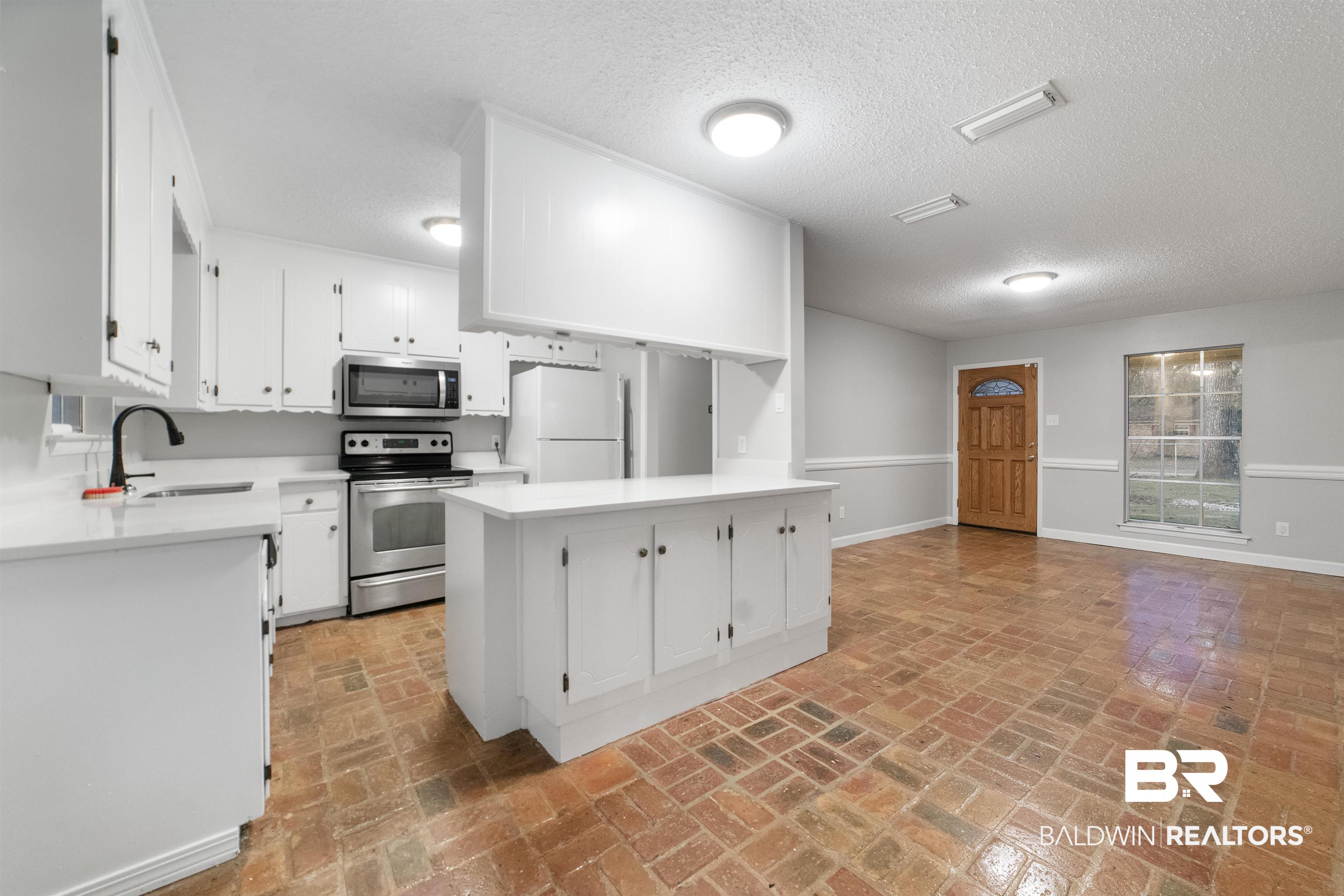 11833 Old Moffat Road Wilmer, AL 36587 - Photo 4 of 23 Kitchen with appliances with stainless steel finishes, light countertops, a sink, and white cabinetry