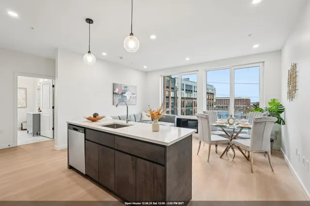 a living room with furniture kitchen view and a large window