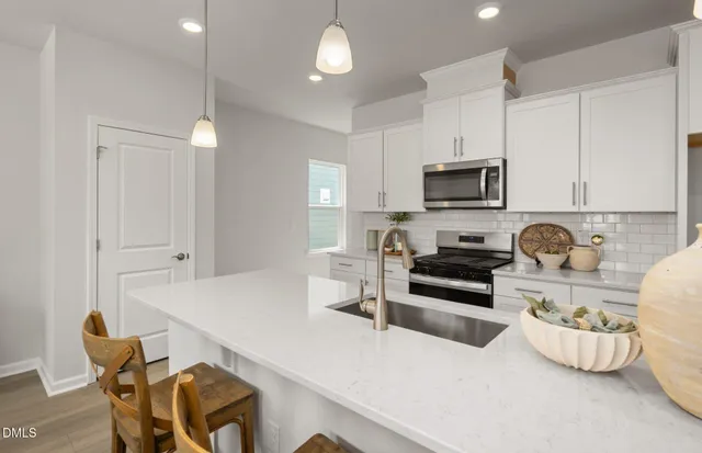 a kitchen with a sink white cabinets and stainless steel appliances
