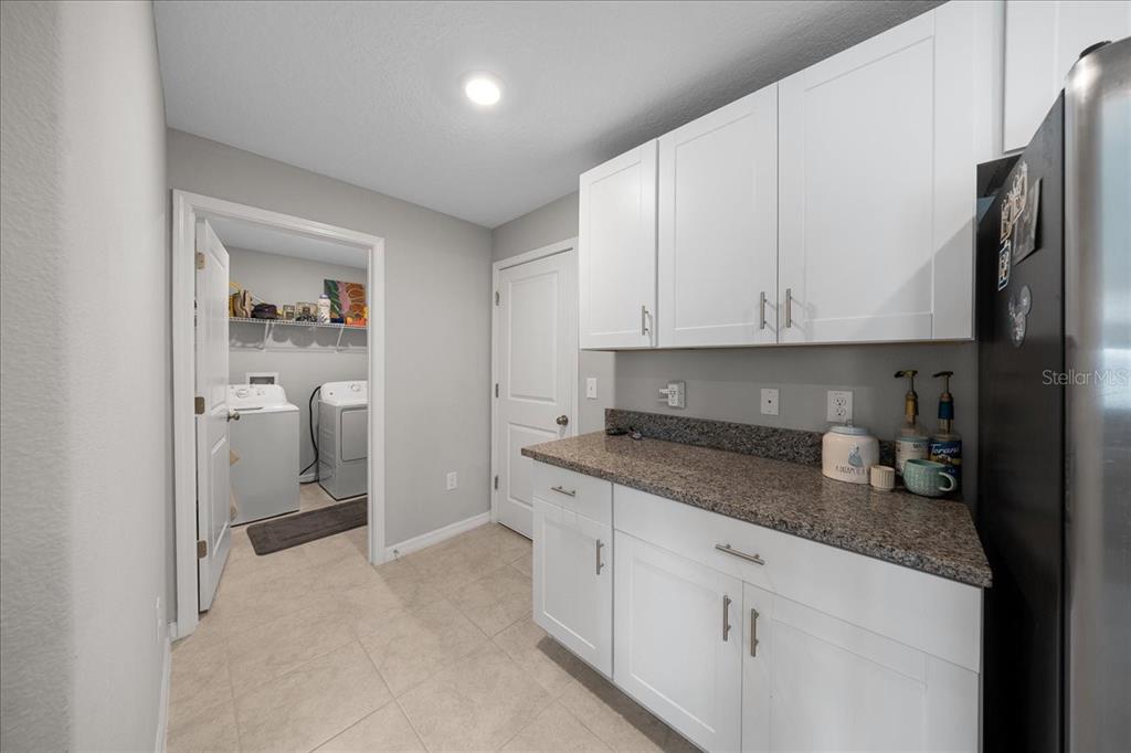 9329 Southwest 57th Terrace Ocala, FL 34476 - Photo 12 of 64 a kitchen with stainless steel appliances granite countertop a refrigerator and white cabinets