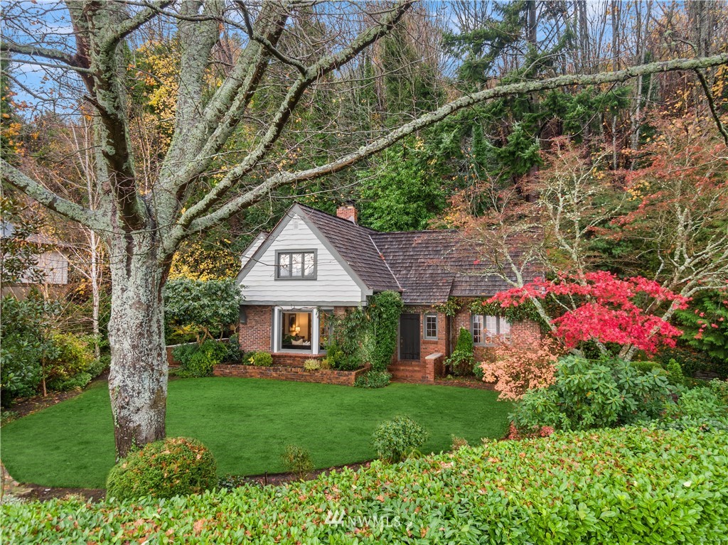 a front view of a house with a yard and fountain in middle