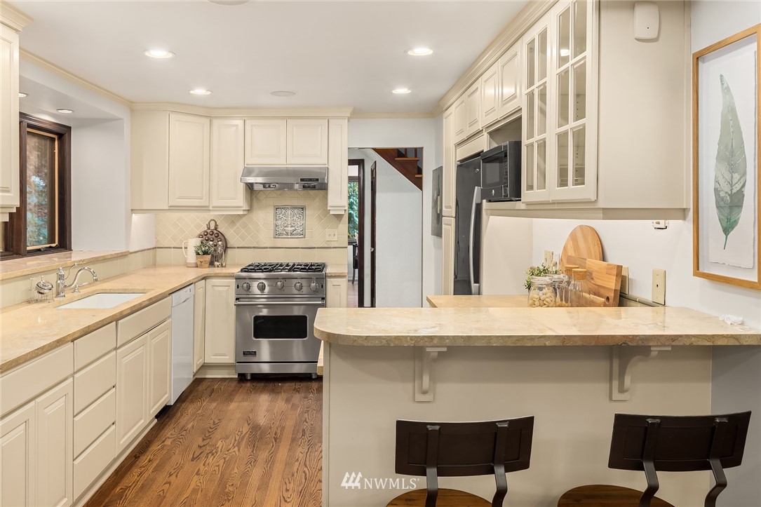 4706 West Ruffner Street Seattle, WA 98199 - Photo 14 of 27 a kitchen with stainless steel appliances granite countertop a stove refrigerator sink and cabinets