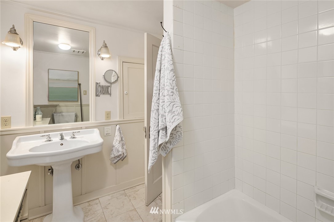 4706 West Ruffner Street Seattle, WA 98199 - Photo 22 of 27 a bathroom with a sink a mirror and shower