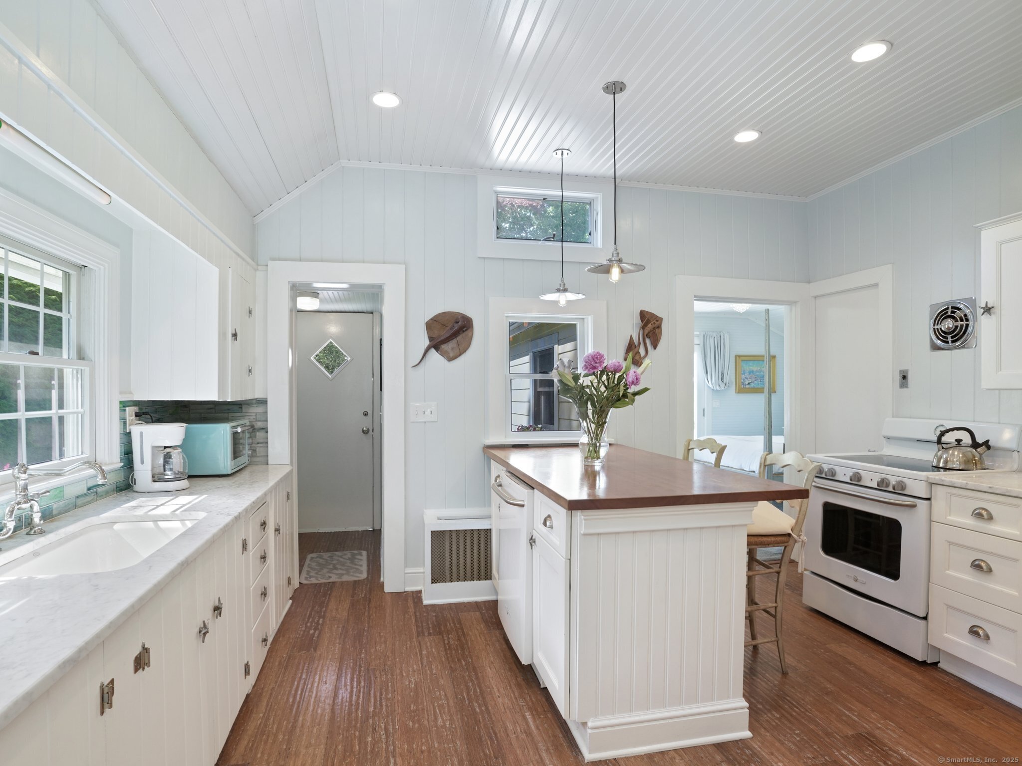 a kitchen with stainless steel appliances kitchen island granite countertop a sink stove and wooden floor