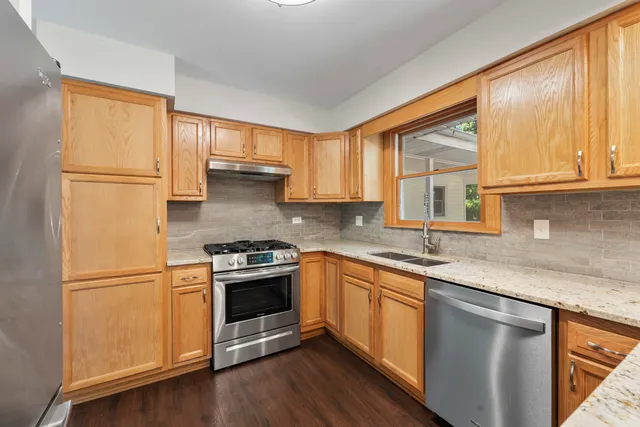 a kitchen with granite countertop a sink stainless steel appliances and cabinets
