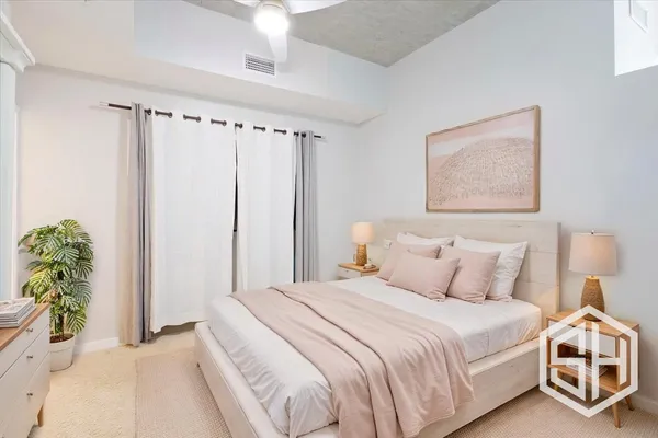 a bedroom with a bed and a potted plant