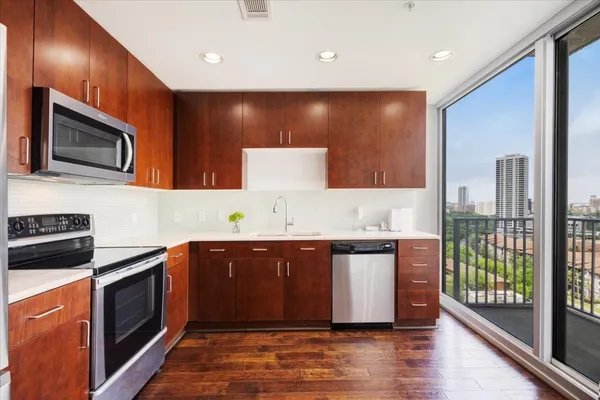 a kitchen with stainless steel appliances granite countertop a stove a sink and a microwave