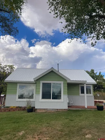 a front view of a house with a garden and yard