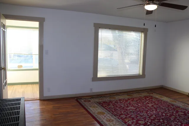 a kitchen with stainless steel appliances granite countertop a sink a stove a refrigerator a microwave a dining table and chairs with wooden floor