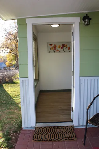 a view of a hallway with wooden floor and a ceiling fan