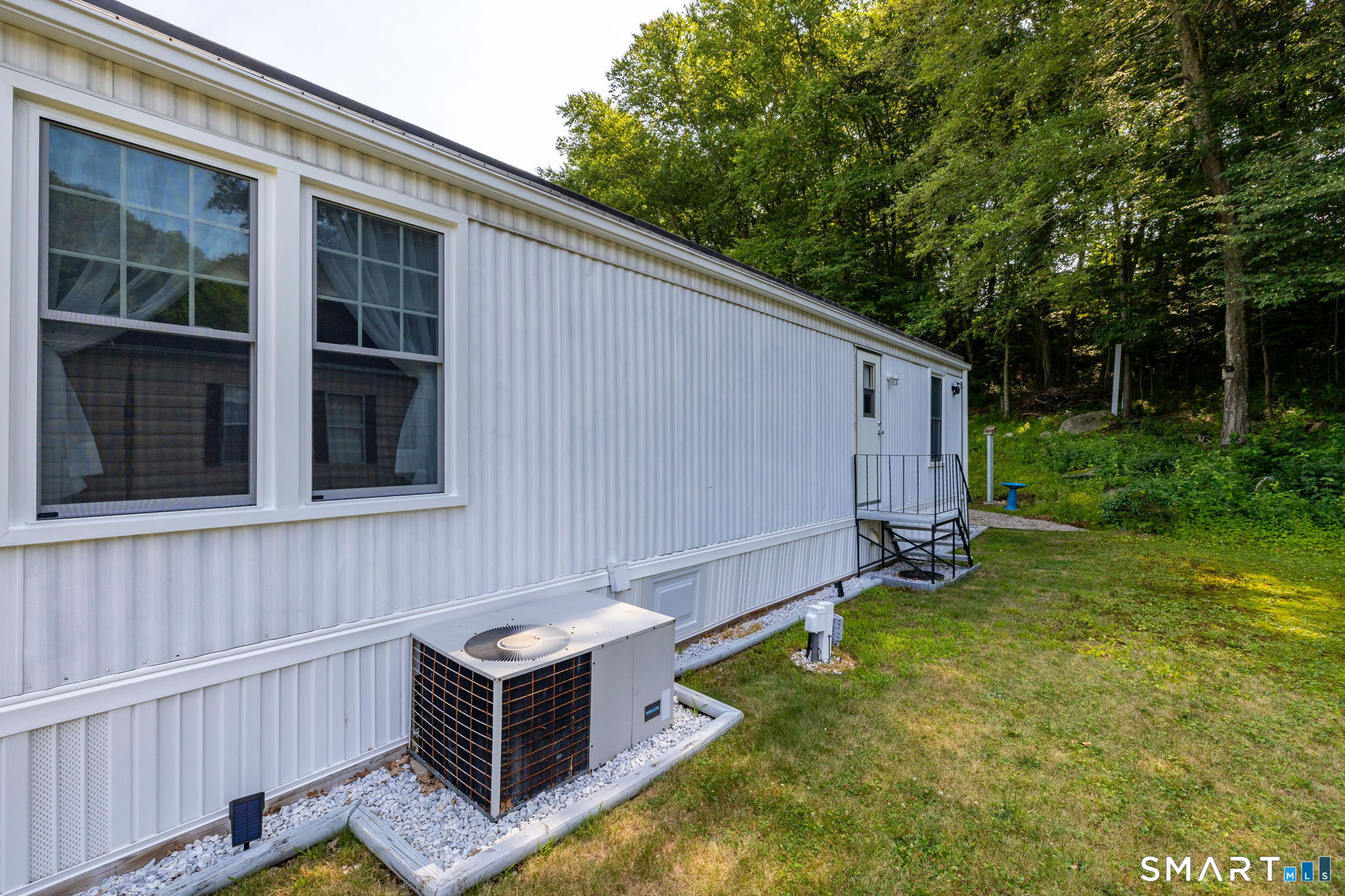 301 Buddington Road Groton, CT 06340 - Photo 24 of 34 a backyard view with hardwood wall and trees