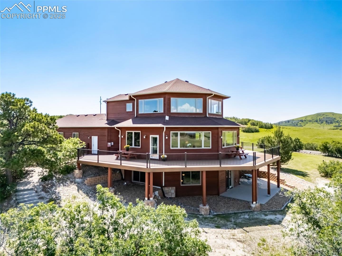 4586 East Best Road Larkspur, CO 80118 - Photo 1 of 50 Rear view of house with a wooden deck and a patio