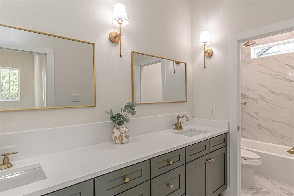 360 Dalton Road Canton, TX 75103 - Photo 25 of 33 Dual vanity with dark cabinetry, white countertops, and brass hardware