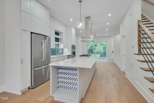 a kitchen with stainless steel appliances granite countertop a refrigerator a sink and a stove