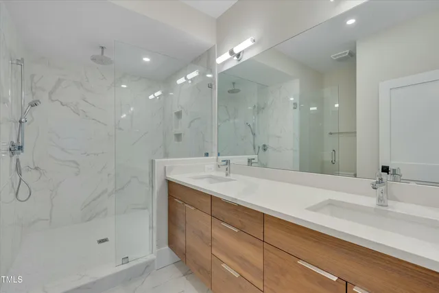 a bathroom with a sink shower and a mirror