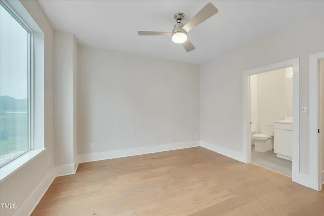 wooden floor in an empty room and a bathroom