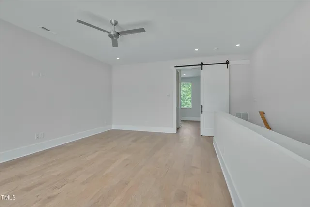 wooden floor in an empty room with a ceiling fan
