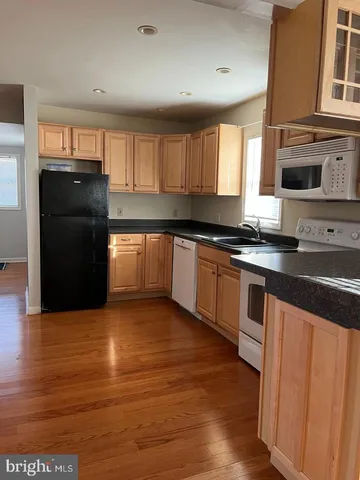 a kitchen with granite countertop a refrigerator and a stove top oven