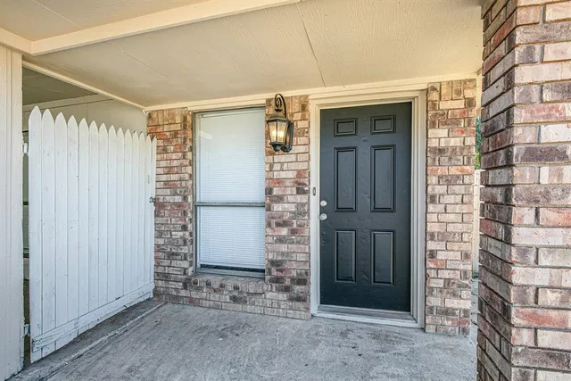 an empty room with wooden floor fireplace and windows