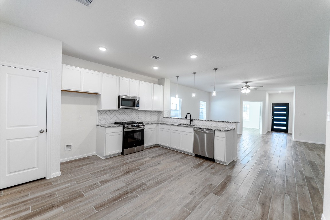 10638 Altitude Way Conroe, TX 77303 - Photo 11 of 29 a large kitchen with a hard wood floor stainless steel appliances and cabinets