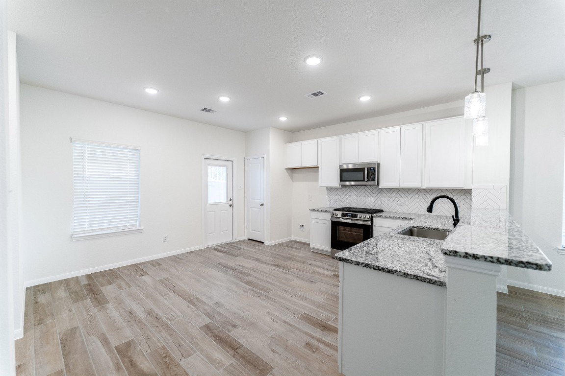 10638 Altitude Way Conroe, TX 77303 - Photo 12 of 29 a large kitchen with granite countertop a large counter top appliances and cabinets