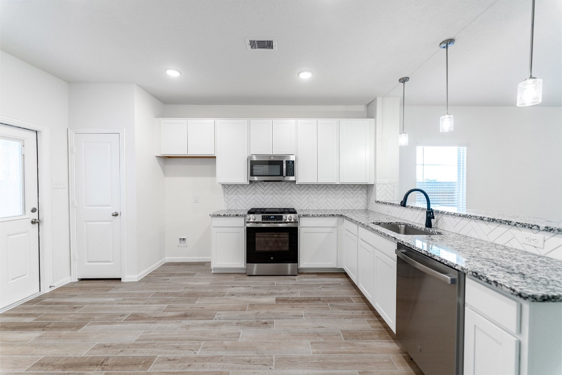 10638 Altitude Way Conroe, TX 77303 - Photo 13 of 29 a large kitchen with granite countertop a stove and a sink