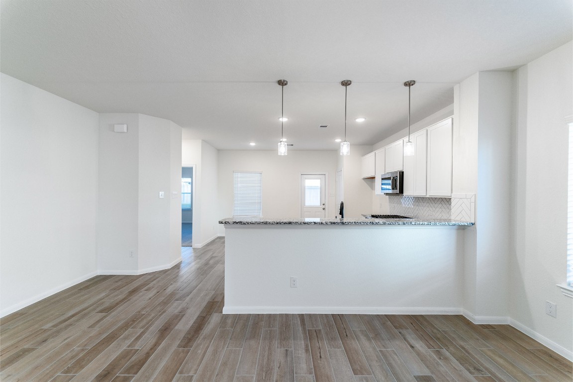 10638 Altitude Way Conroe, TX 77303 - Photo 14 of 29 a large white kitchen with wooden floors and kitchen view