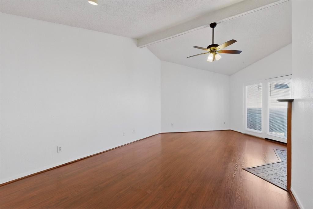 8545 Midpark Road, Unit 16 Dallas, TX 75240 - Photo 4 of 29 Spare room with beamed ceiling, dark wood-type flooring, a ceiling fan, and a textured ceiling