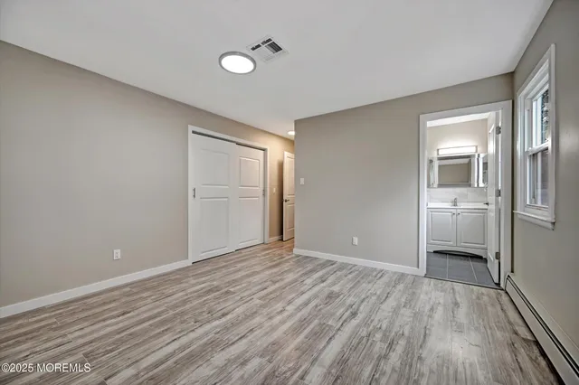 a view of a big room with wooden floor and a kitchen