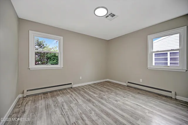 a view of room with window and wooden floor