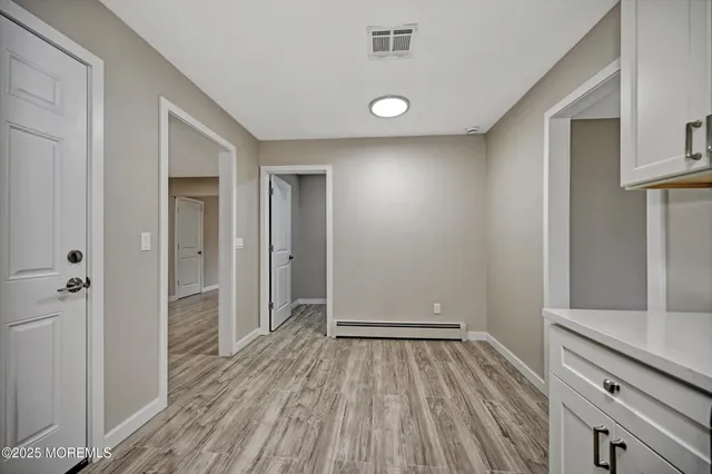 a view of a hallway with wooden floor and closet