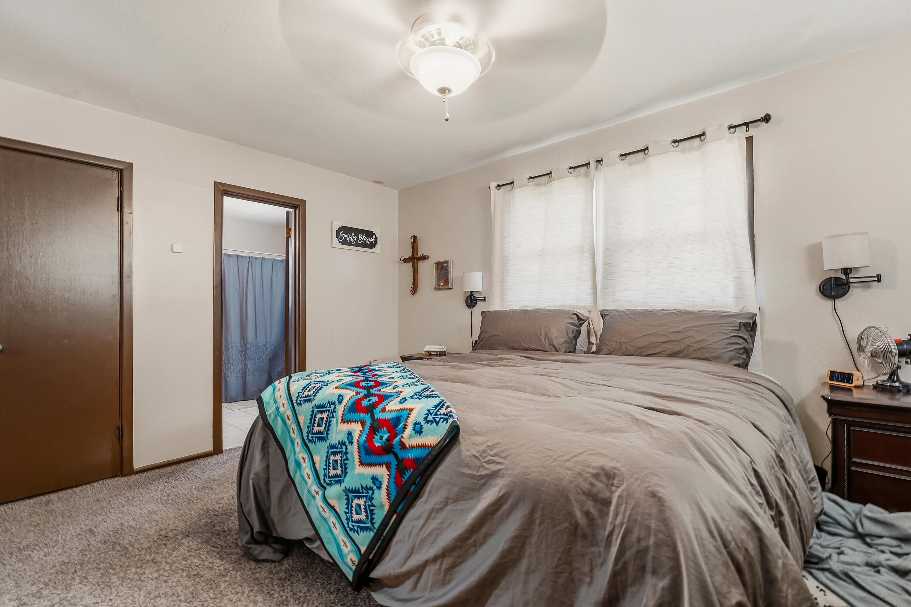 707 12th Street Shallowater, TX 79363 - Photo 18 of 27 a bedroom with a bed and a chandelier