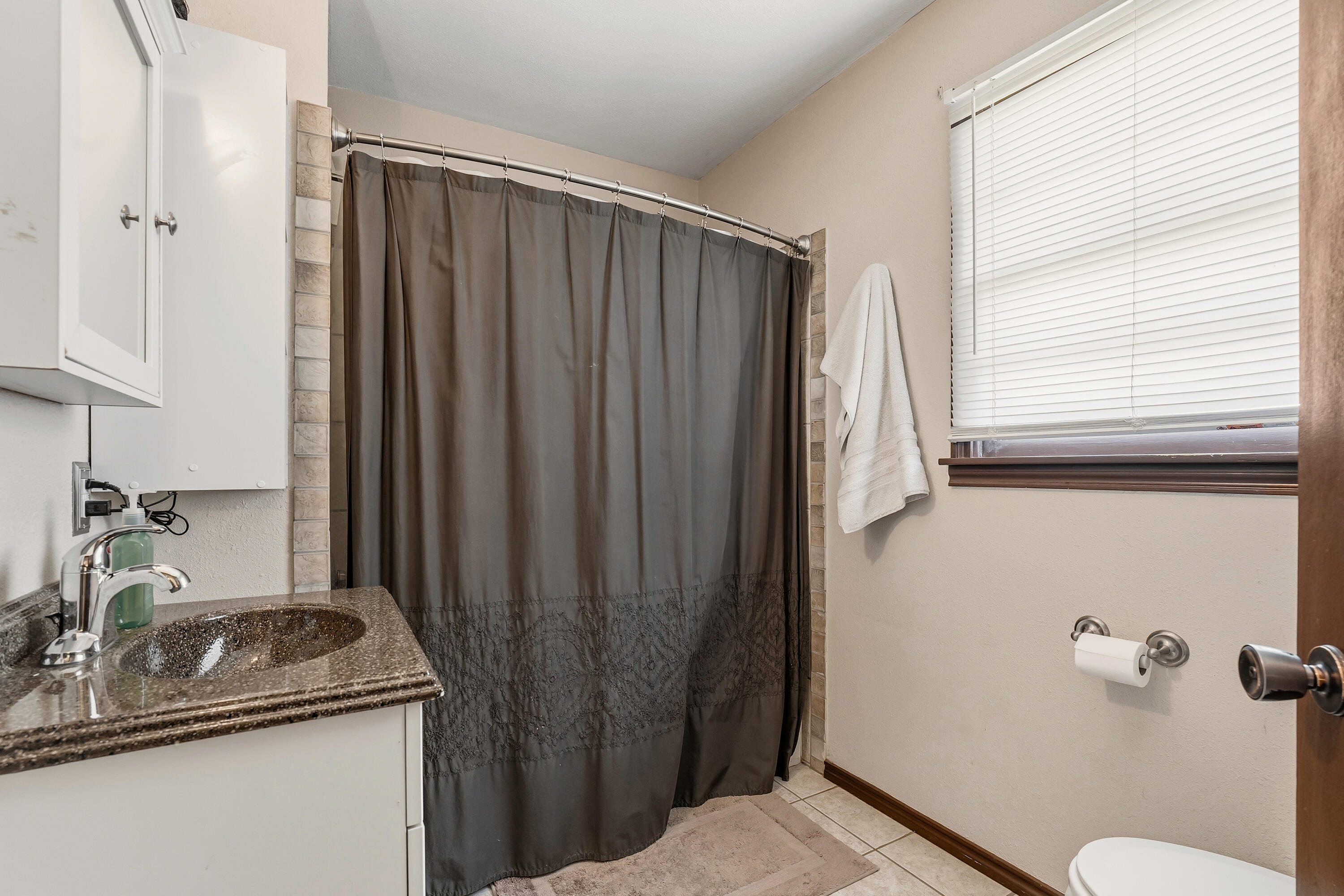 707 12th Street Shallowater, TX 79363 - Photo 20 of 27 a bathroom with a granite countertop sink and a mirror