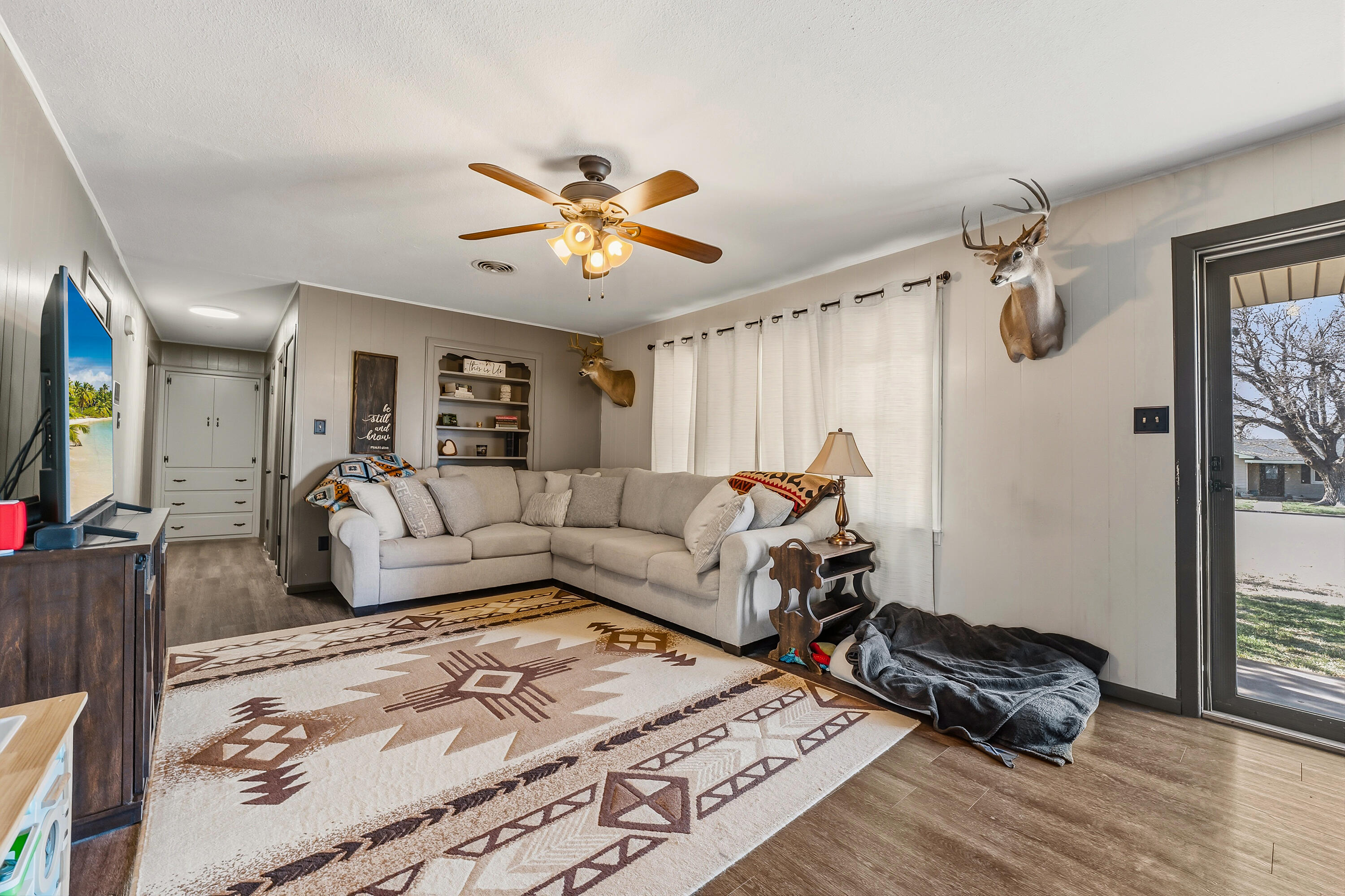 707 12th Street Shallowater, TX 79363 - Photo 6 of 27 a living room with furniture ceiling fan and a wooden floor