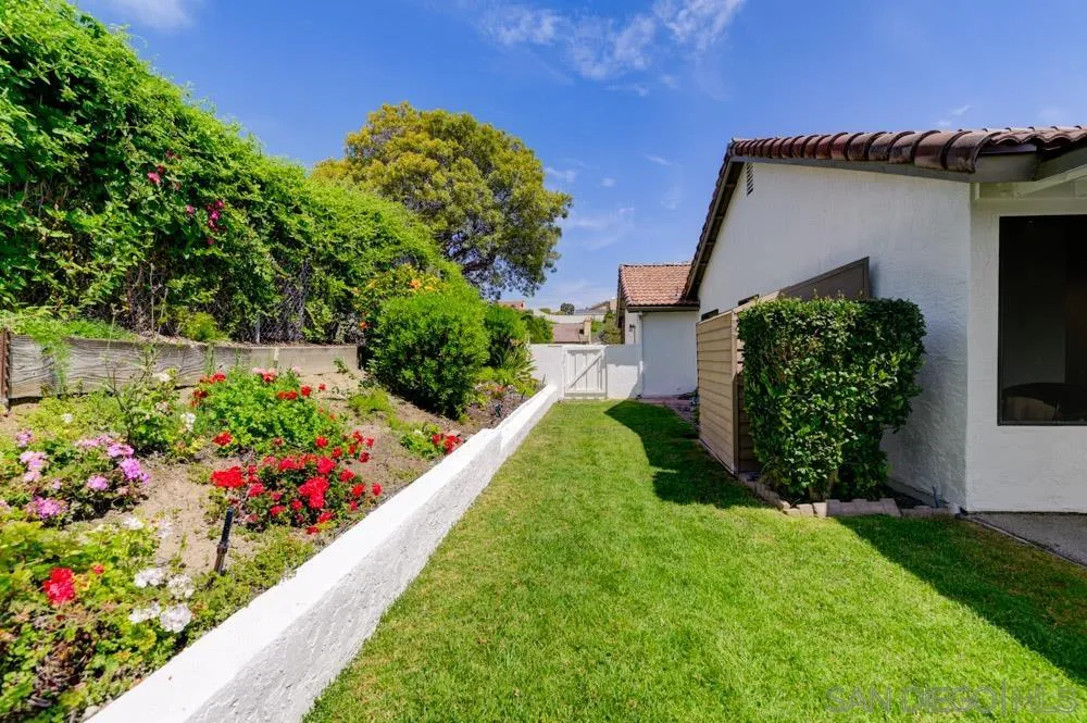 4635 Briar Ridge Road Oceanside, CA 92056 - Photo 22 of 23 a view of a garden with flowers and wooden fence